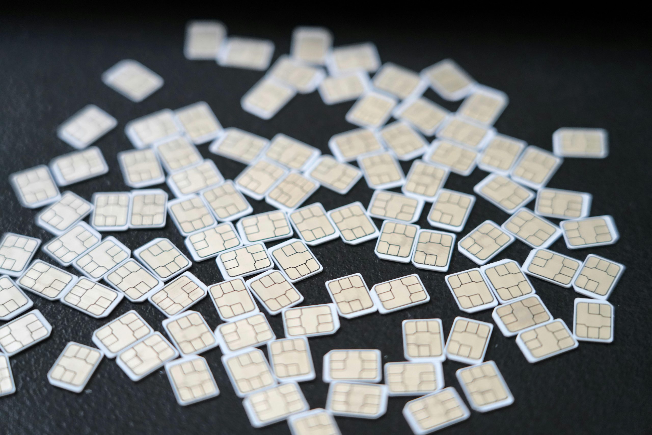 A bunch of sim cards on a black desk